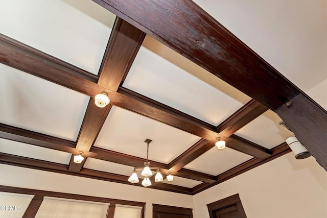 room details featuring beamed ceiling, coffered ceiling, and a notable chandelier