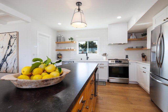 kitchen with decorative backsplash, custom range hood, stainless steel appliances, light hardwood / wood-style flooring, and white cabinets