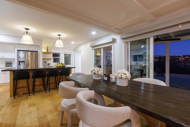 dining space featuring ceiling fan, light hardwood / wood-style floors, and beam ceiling