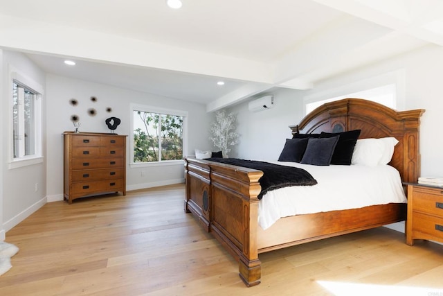 bedroom with beam ceiling, light wood-type flooring, and a wall mounted AC