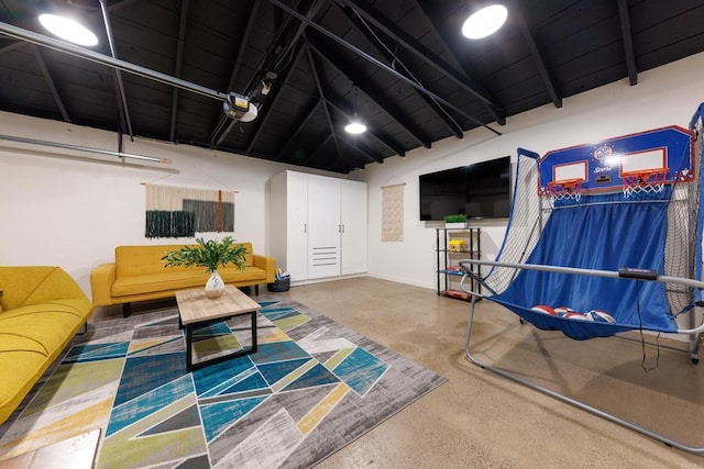 interior space featuring concrete flooring and lofted ceiling with beams