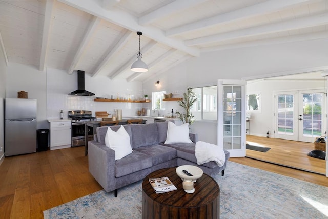 living room featuring hardwood / wood-style floors, vaulted ceiling with beams, sink, and french doors