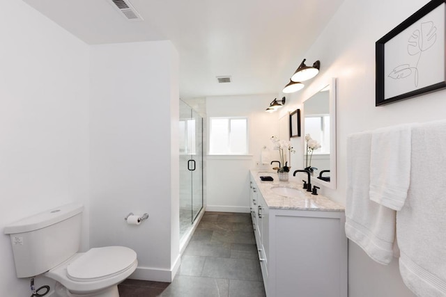 bathroom with tile patterned floors, vanity, a shower with shower door, and toilet