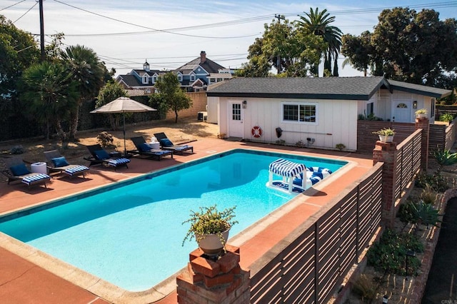 view of pool with an outbuilding and a patio