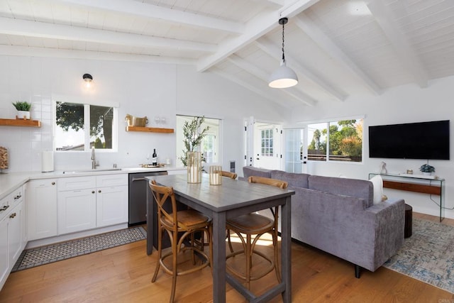 kitchen featuring white cabinetry, dishwasher, pendant lighting, and light hardwood / wood-style flooring