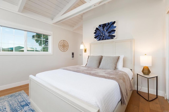 bedroom featuring lofted ceiling with beams and light hardwood / wood-style flooring