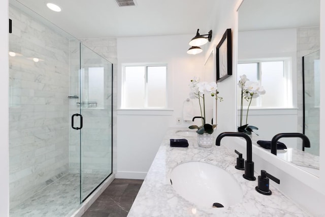 bathroom with a shower with door and vanity