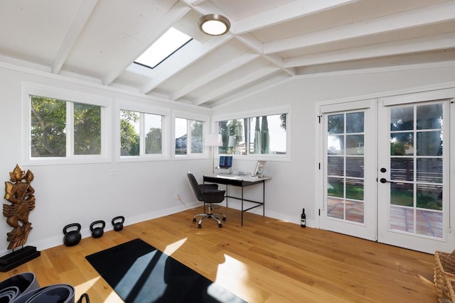 office area with a wealth of natural light, lofted ceiling with skylight, french doors, and wood-type flooring