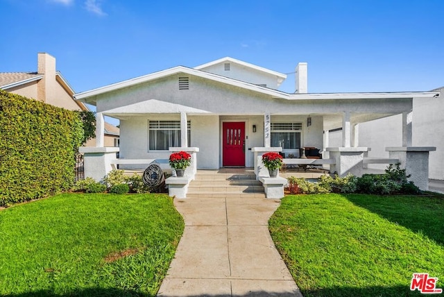 view of front of house with covered porch and a front yard