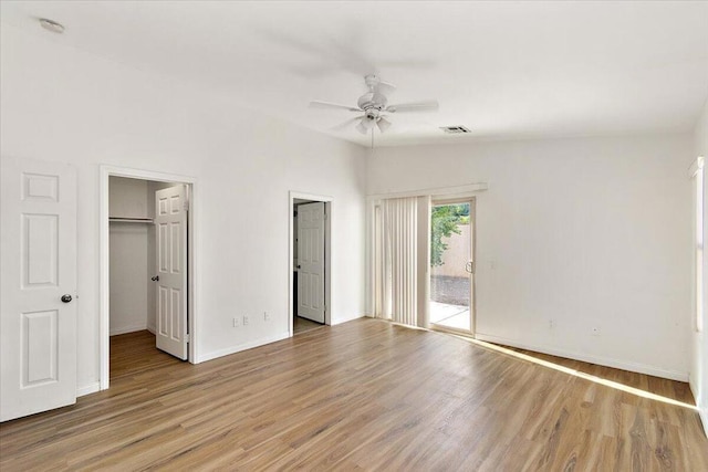 unfurnished bedroom featuring access to outside, light hardwood / wood-style floors, vaulted ceiling, and ceiling fan