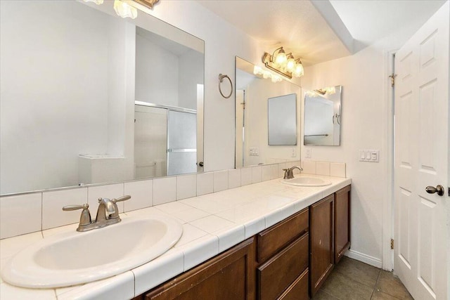 bathroom featuring tile patterned flooring, vanity, and a shower with door