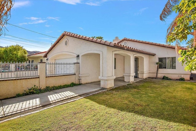 mediterranean / spanish-style home with a garage and a front lawn