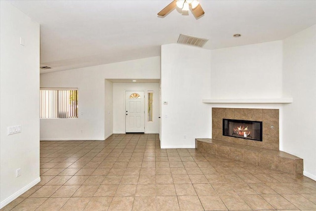 unfurnished living room featuring a tile fireplace, ceiling fan, light tile patterned floors, and lofted ceiling