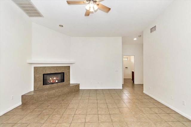 unfurnished living room featuring light tile patterned flooring, ceiling fan, and a tiled fireplace