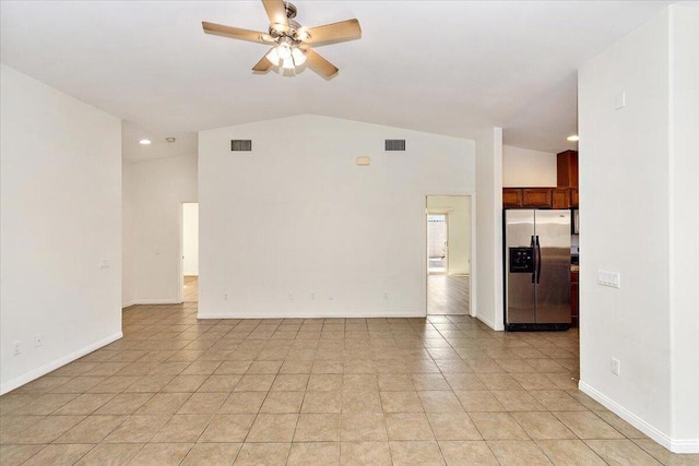 unfurnished living room with ceiling fan, light tile patterned floors, and vaulted ceiling