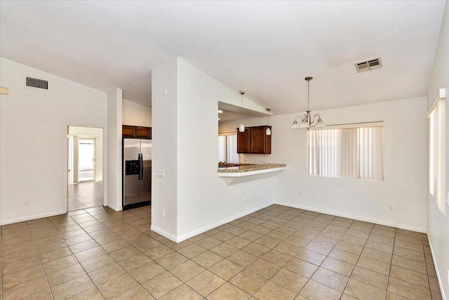 unfurnished living room with light tile patterned floors, vaulted ceiling, and a notable chandelier