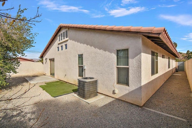 view of property exterior featuring cooling unit and a patio area