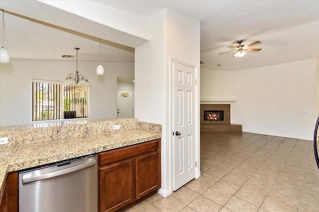 kitchen with stainless steel dishwasher, pendant lighting, vaulted ceiling, light tile patterned floors, and ceiling fan with notable chandelier