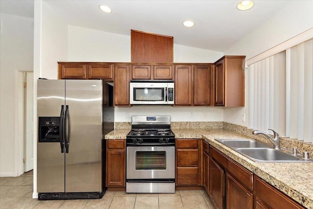 kitchen with sink, light tile patterned floors, stainless steel appliances, and lofted ceiling