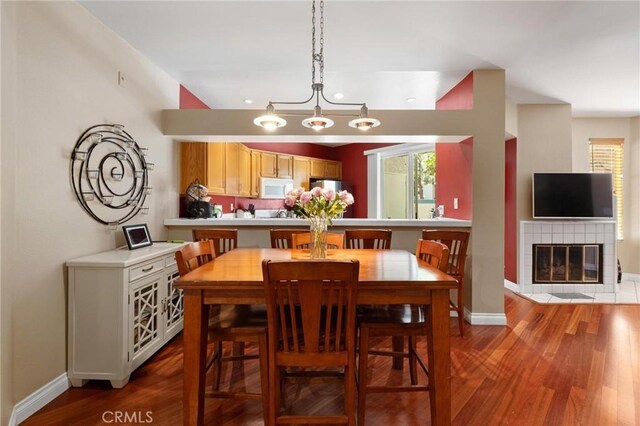 dining area with a fireplace and hardwood / wood-style flooring