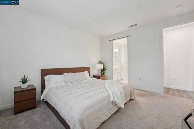 carpeted bedroom featuring ensuite bath