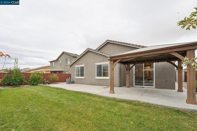 back of house with a gazebo, a lawn, cooling unit, and a patio