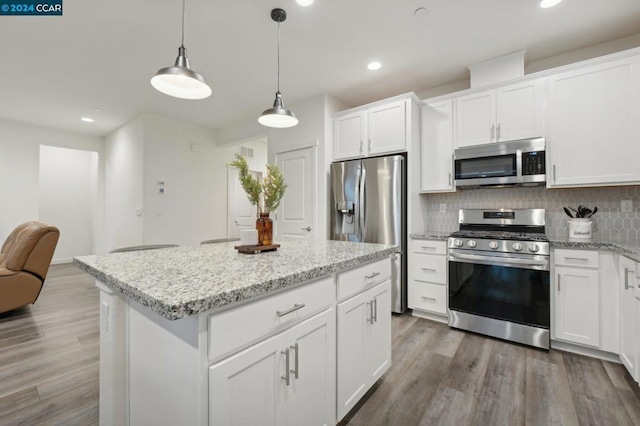 kitchen featuring a kitchen island, white cabinetry, dark wood-type flooring, and appliances with stainless steel finishes