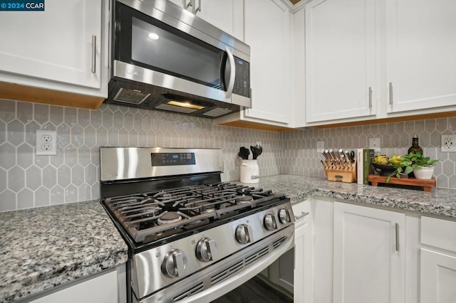 kitchen featuring white cabinetry, light stone counters, and appliances with stainless steel finishes