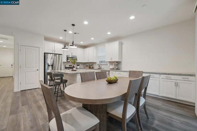 dining space featuring sink and dark wood-type flooring