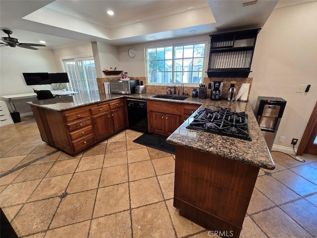 kitchen with kitchen peninsula, sink, a tray ceiling, and black appliances