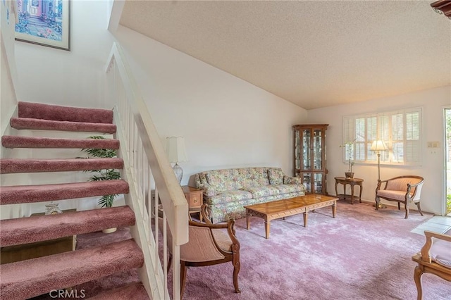 living room featuring lofted ceiling, carpet floors, and a textured ceiling