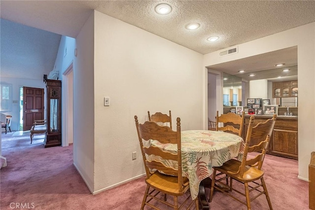 dining space featuring carpet floors, sink, and a textured ceiling