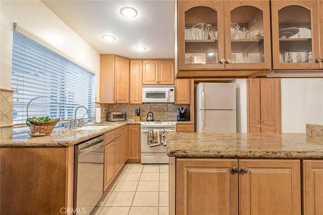 kitchen with light stone counters, sink, white appliances, and light tile patterned floors