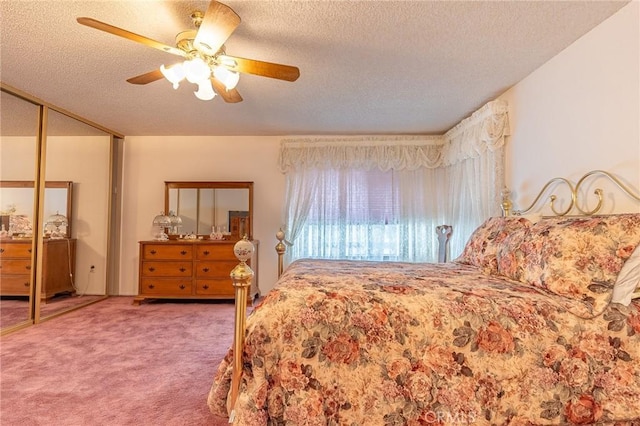 carpeted bedroom with ceiling fan and a textured ceiling