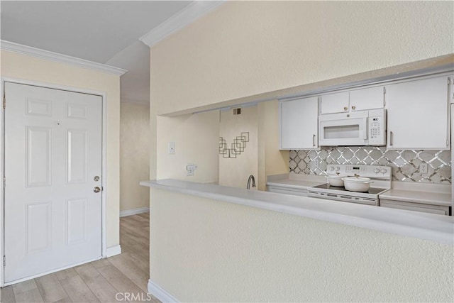 kitchen featuring tasteful backsplash, ornamental molding, white appliances, light hardwood / wood-style floors, and white cabinetry