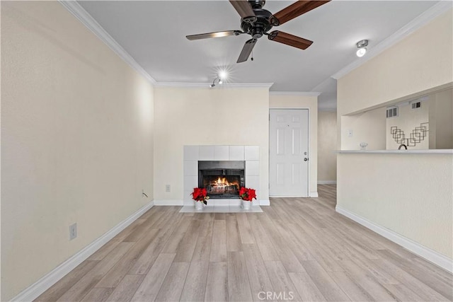 unfurnished living room featuring ceiling fan, light hardwood / wood-style floors, crown molding, and a fireplace