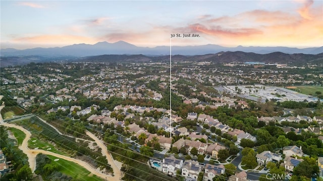 aerial view at dusk featuring a mountain view