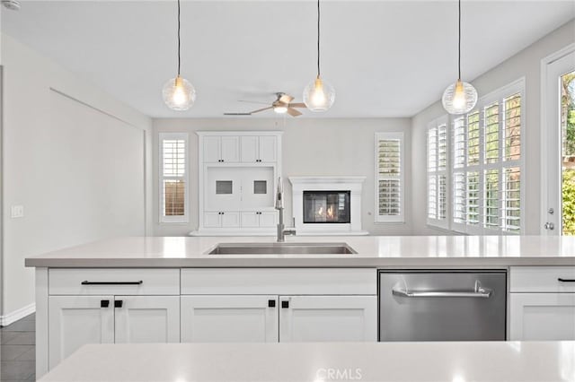 kitchen with dishwasher, pendant lighting, white cabinetry, and sink