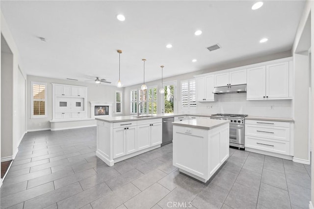 kitchen with pendant lighting, a center island, white cabinets, kitchen peninsula, and stainless steel appliances