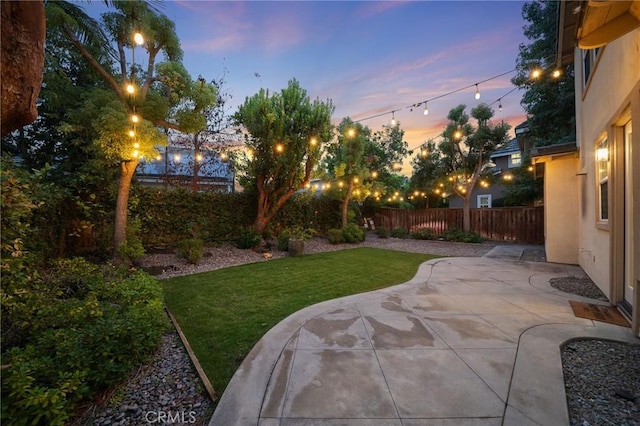 yard at dusk featuring a patio area