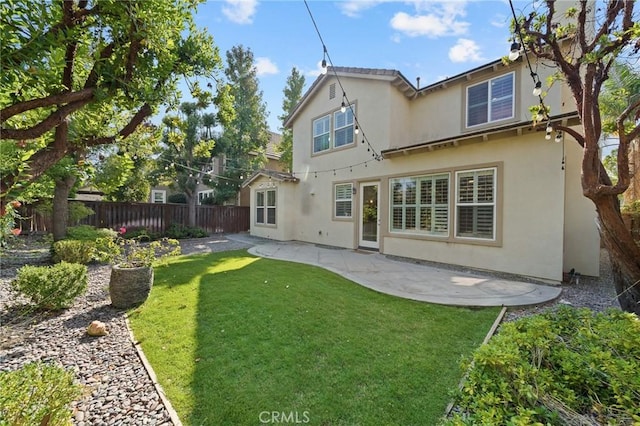 back of property featuring a lawn and a patio