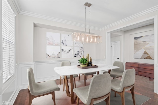 dining area with crown molding, dark wood-type flooring, and a notable chandelier