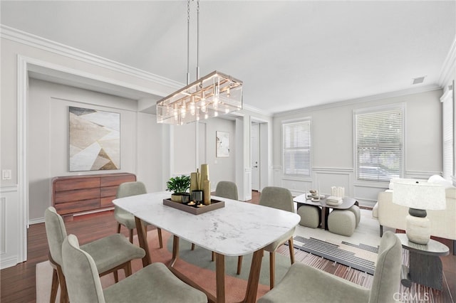 dining space with ornamental molding and dark wood-type flooring