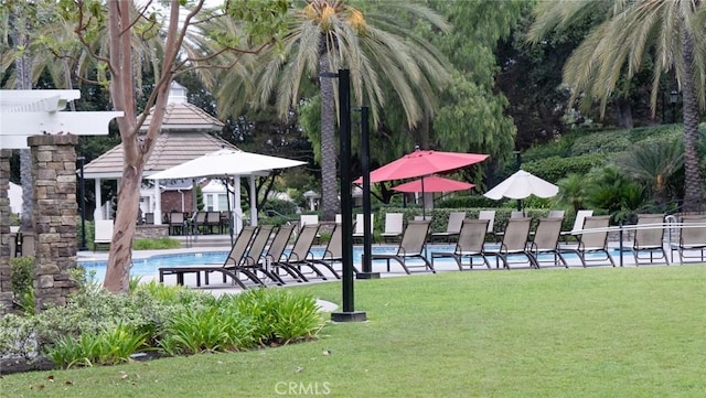 view of community featuring a lawn and a swimming pool