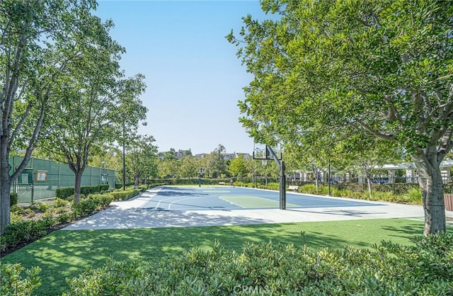 view of sport court with a lawn