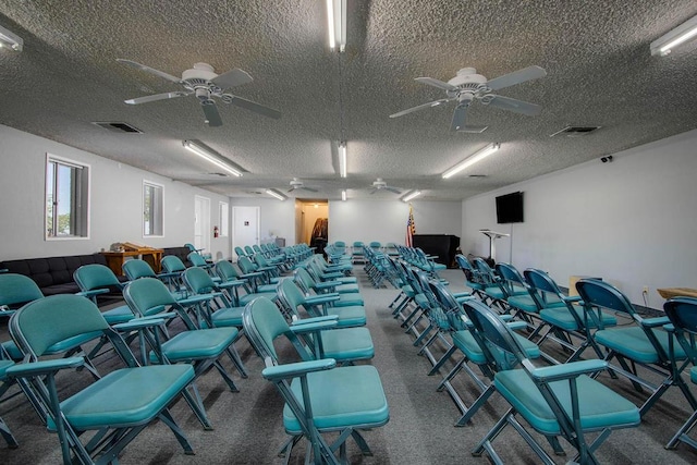 interior space with carpet, a textured ceiling, and ceiling fan