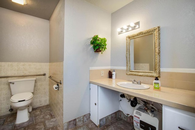 bathroom featuring sink, tile walls, and toilet