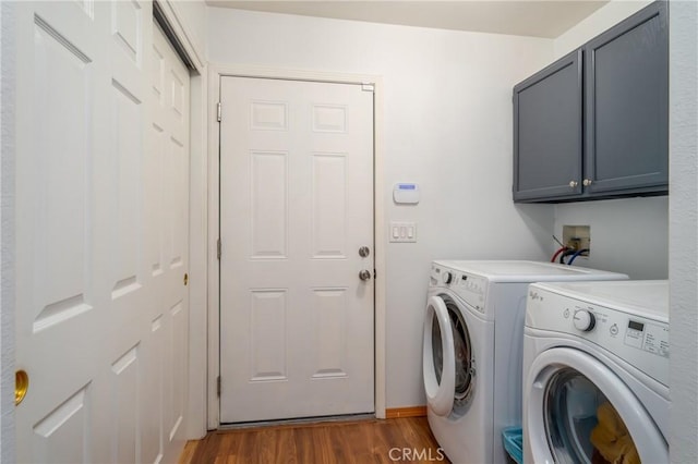 laundry area with cabinets, independent washer and dryer, and dark hardwood / wood-style floors