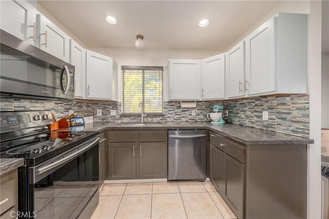 kitchen featuring white cabinets, appliances with stainless steel finishes, light tile patterned floors, and sink