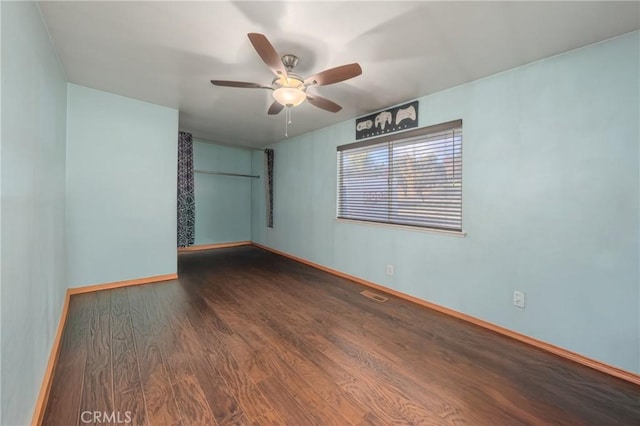 spare room with ceiling fan and dark wood-type flooring